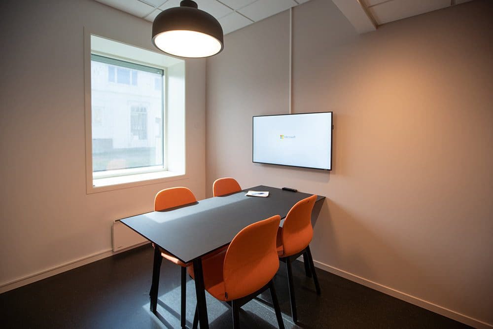 Bilde av et møterom for 4 personer med skjerm på veggen