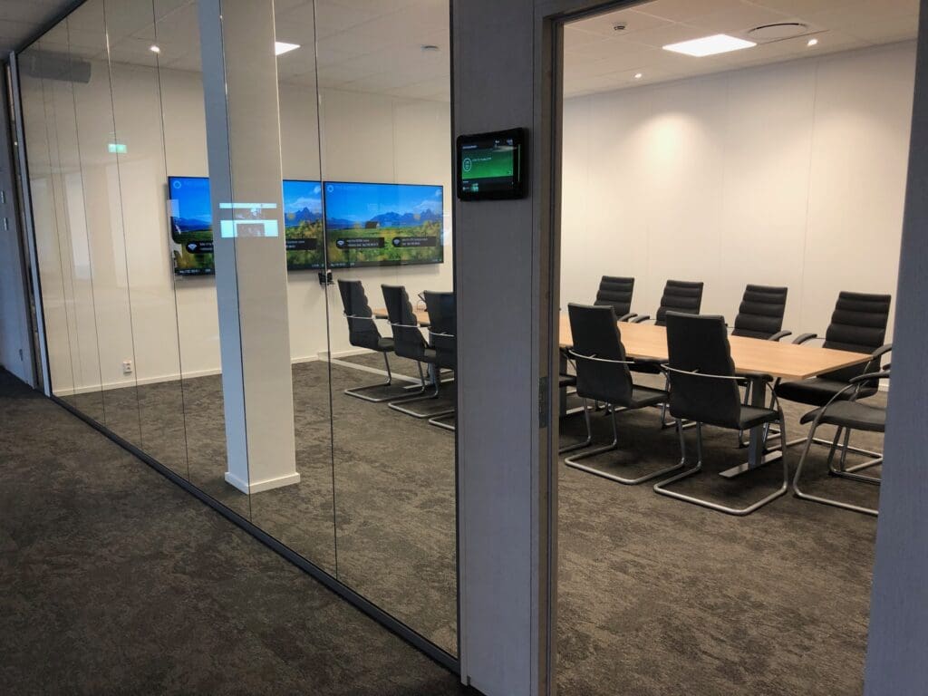 Bildet viser et møterom med skjermer på veggen