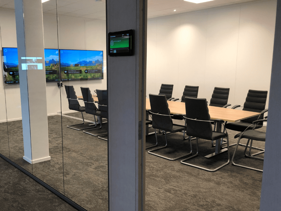 Bilde viser et møterom (Teams-rom), med skjermer på veggen